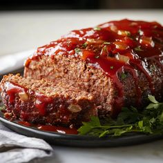 meatloaf with ketchup and parsley on a black plate, ready to be eaten