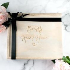 a wedding guest book with flowers and ribbon on the cover, sitting on a marble surface