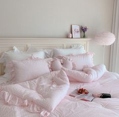 a bed with pink comforters and pillows on it