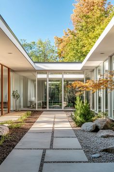 the entrance to a modern house with large windows and stone walkway leading up to it