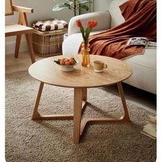 a living room scene with focus on the coffee table and flowers in front of the couch