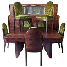 a dining room table and chairs with green velvet upholstered seats on each side