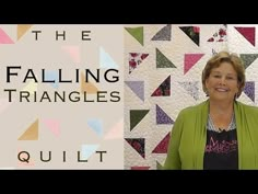 a woman standing in front of a quilt with the words falling triangles quilt on it