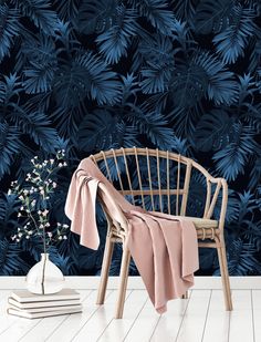 a chair with a pink blanket on it in front of a dark blue wallpaper