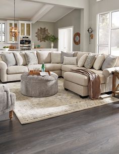 a living room filled with furniture on top of a hard wood floor covered in rugs