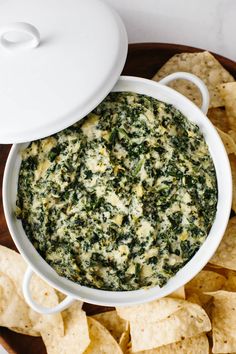 spinach dip in a bowl with tortilla chips on the side