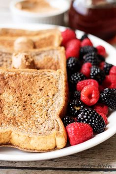 french toast with berries and raspberries on a white plate