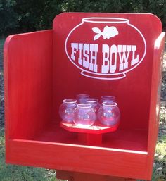 fish bowl display with four small glass jars on it's stand in the grass