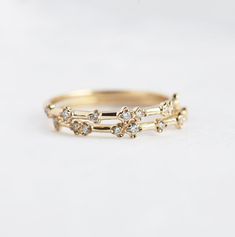 two gold wedding bands with small diamonds on each band, set against a white background