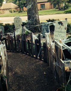 a wooden fence decorated with halloween decorations and ghost net hanging from it's sides