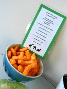 a blue bowl filled with cheetos sitting on top of a table next to a sign