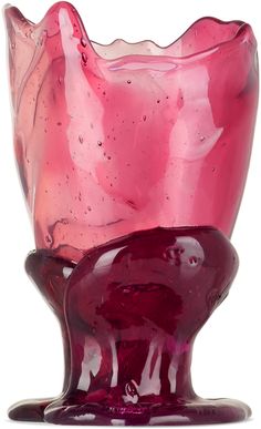 a pink glass vase sitting on top of a white table