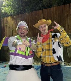 two men in costumes standing next to each other and making the peace sign with their hands