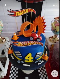 a birthday cake is decorated with cars and numbers on the top, along with balloons