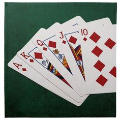 four playing cards are laying on top of each other in the middle of a green table