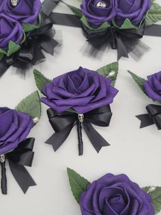 six purple roses with black ribbons and bows