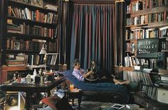 a living room filled with lots of books and furniture