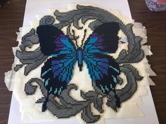 a piece of art made out of paper with a blue and purple butterfly on it