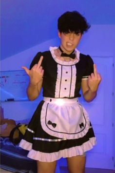 a woman in a maid outfit making the peace sign