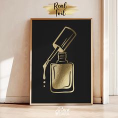 a black and gold framed poster with a bottle of nail polish on the wall next to it