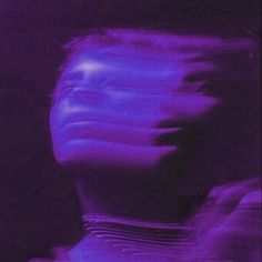 a blurry image of a man's face in purple light