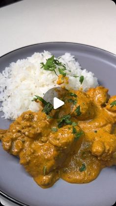 a plate with rice, meat and sauce on it next to a knife in the middle