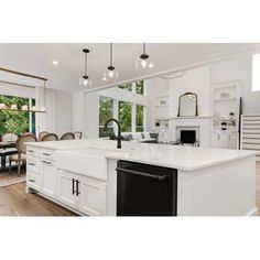 a large kitchen with an island in front of a dining room table and stairs leading up to the second floor