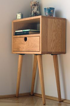 a small wooden table with two drawers on it and a teddy bear next to it