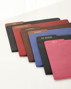 five different colored folders on a white surface