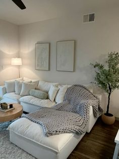 a living room filled with furniture and a large white couch in front of a window