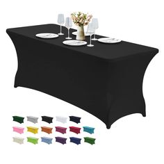 a black table cloth with white plates and wine glasses on it, all in different colors