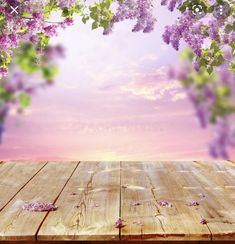 an empty wooden table with purple flowers on the top and sky in the back ground