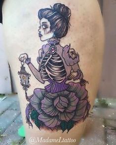 a tattoo on the side of a woman's leg with a skeleton and flowers