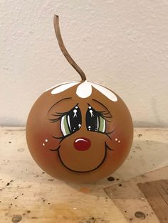 a painted pumpkin sitting on top of a wooden table