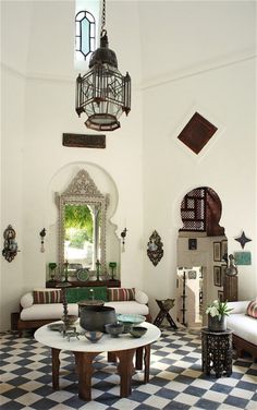 a living room filled with furniture and a chandelier hanging from the ceiling over a checkered floor