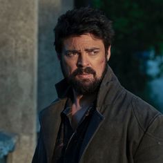 a man with a goatee and beard in a leather jacket looking at the camera