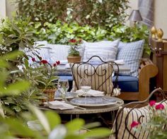 an outdoor patio with chairs, tables and plants