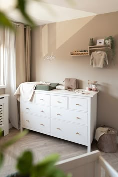 a baby's room with a dresser and crib