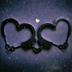 two handcuffs shaped like hearts with the word am spelled in them on a dark background