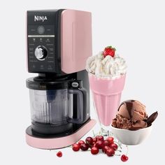 an ice cream sundae next to a pink ninja coffee maker and a bowl of cherries