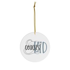 a white ornament with the word conceurs on it hanging from a string