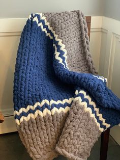 a blue and gray blanket sitting on top of a wooden chair