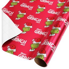 the grinch wrapping paper is red with green heads and santa's hat on it