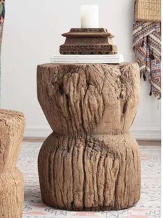 a wooden table with a candle on top of it and two stools next to it