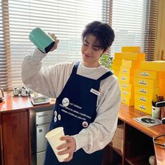 a person in an apron holding a cup