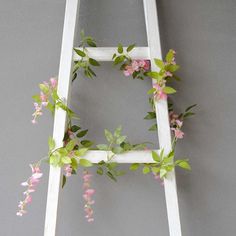 a ladder decorated with pink flowers and green leaves