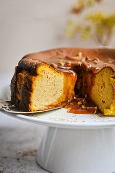 a bundt cake on a white plate with a piece cut out and drizzled with caramel