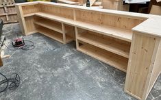 a wooden bench sitting on top of a floor next to a pile of wood crates