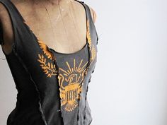 a mannequin wearing a black top with an orange and yellow design on it