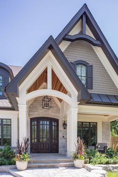 a house with two large planters in front of it and an entry way leading to the second floor